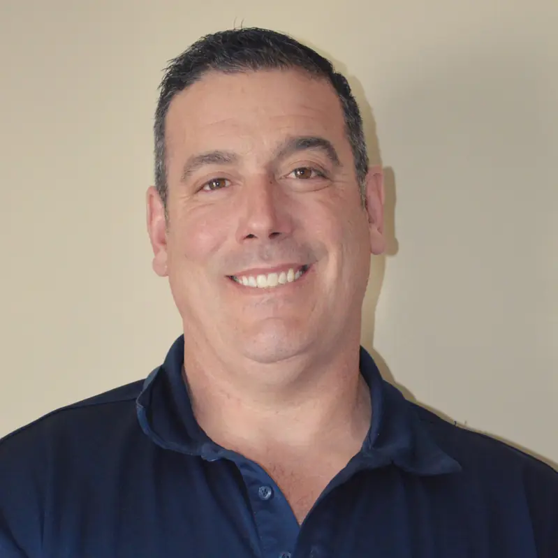 Chris Cimaglio, owner of Cmags HVAC, in a navy polo shirt with the company logo